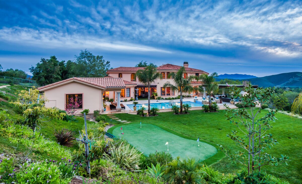 The 1.5-acre estate includes a 7,500-square-foot villa, pool house, swimming pool, spa, putting green and pavilion.