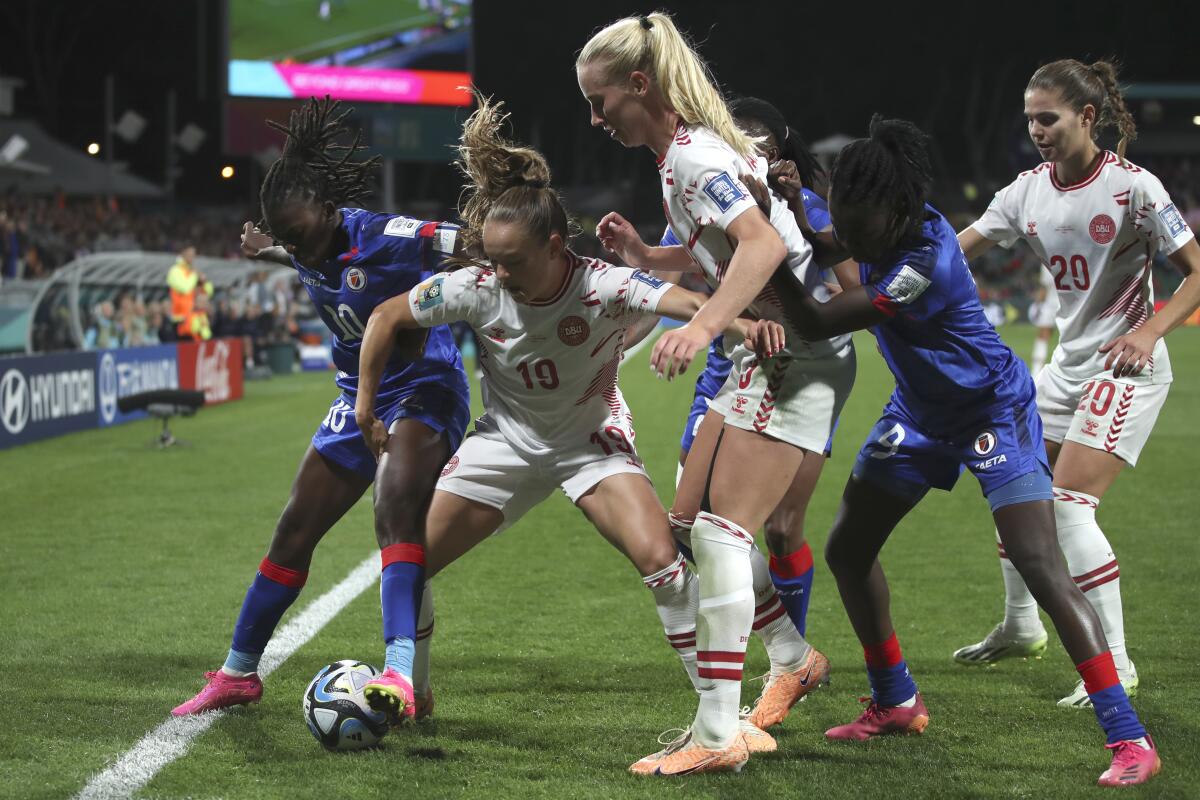 Haiti and Denmark battle for control of the ball.