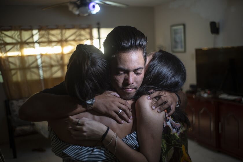 Marcos Marzo hugs two of his friends who came to say goodbye upon receiving the news that he had obtained a permit to travel to the United States, in Havana, Cuba, Wednesday, Jan 25, 2023. Now in the U.S., his dream is to do a master’s degree at the Massachusetts Institute of Technology and work as an engineer, which he says is his passion. (AP Photo/Ramon Espinosa)