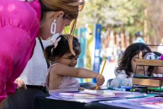 Olivia Olverado, 2, dibuja en la mesa de dibujos y poemas durante el Festival de Libros de Los Angeles Times el domingo.