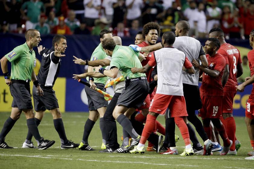 Referee Mark Geiger, left, is charged by some Panama players at the conclusion of a CONCACAF Gold Cup semifinal game won by Mexico on Wednesday.