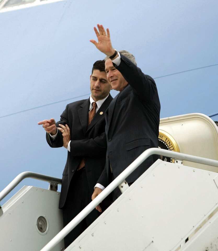 President Bush waves as he steps off Air Force One with Rep. Paul Ryan, left, R-Wisc., in Milwaukee.