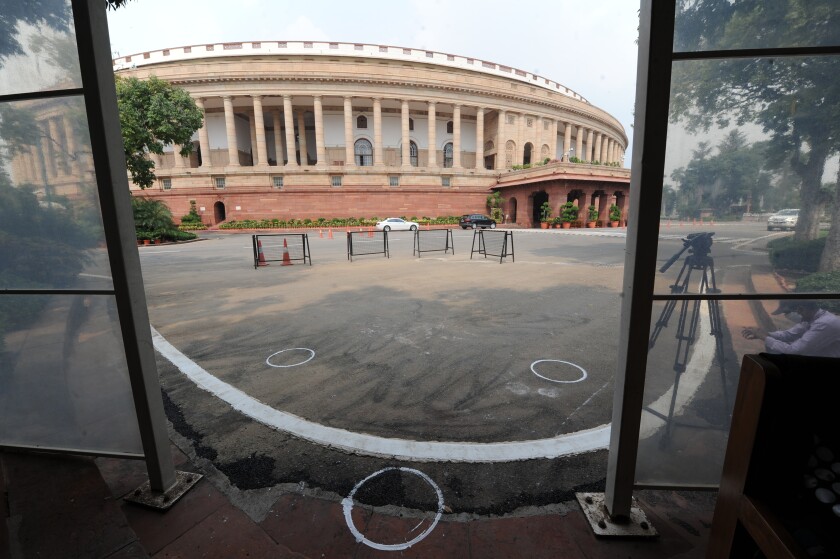 FILE- In this Sept.14, 2020 file photo, markings to maintain physical distancing are seen on the ground outside the Parliament building in New Delhi, India. India’s government is repealing a controversial tax law under which it pursued billions of dollars from international companies for their past dealings and hopes that scrapping the retrospective levy boosts investor confidence. The bill approved in Parliament’s upper house Monday proposes to withdraw tax demands made over indirect transfers of Indian assets prior to May 2012.(AP Photo, File)