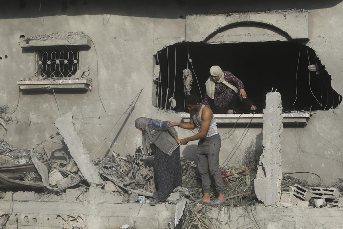 Palestinos evacúan un edificio dañado 