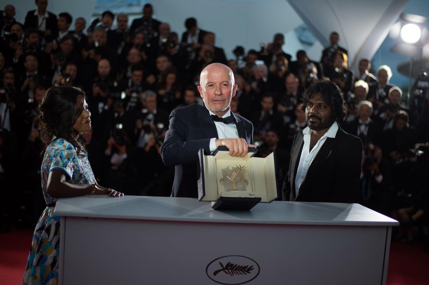 French director Jacques Audiard (C) holds his prize as he poses with Sri Lankan actress Kalieaswari Srinivasan (L) and Sri Lankan actor Jesuthasan Antonythasan during a photocall after he was awarded with the Palme d'Or for his film "Dheepan" during the closing ceremony of the 68th Cannes Film Festival in Cannes, southeastern France, on May 24, 2015. AFP PHOTO / BERTRAND LANGLOISBERTRAND LANGLOIS/AFP/Getty Images ** OUTS - ELSENT, FPG - OUTS * NM, PH, VA if sourced by CT, LA or MoD **