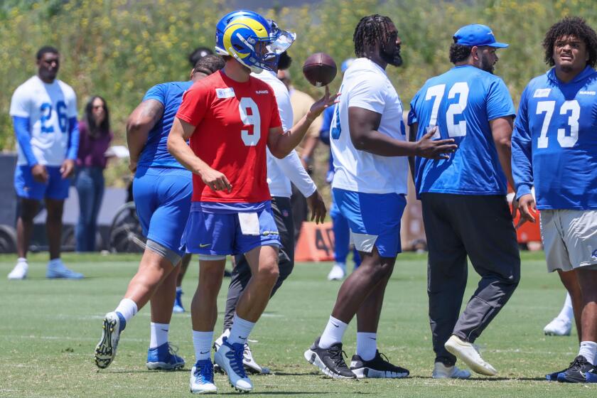 Quarterback Matthew Stafford flips the football during a Rams OTA practice. 