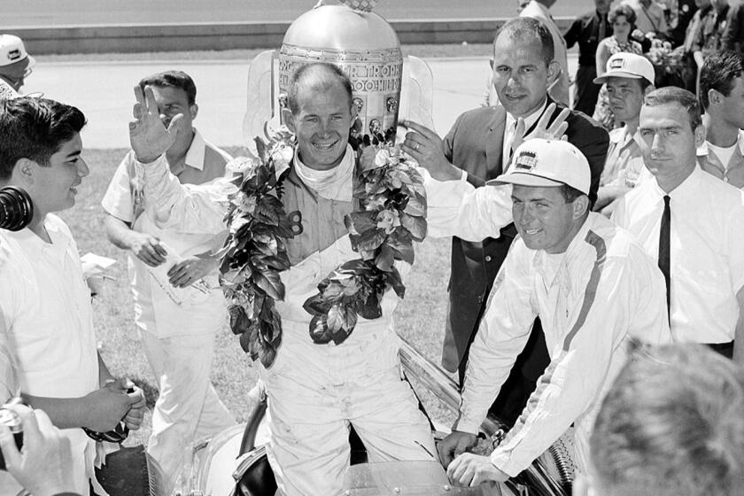 Parnelli Jones, wearing the victory wreath around his neck, stands up in his Agajanian?Willard Special in front of the trophy cup at the Indianapolis Motor Speedway after the 500?mile race in Indianapolis, Indiana, May 30, 1963. Jones won the 47th running of the speed race in record time of 143.137 miles per hour. (AP Photo)
