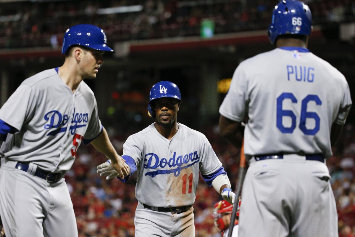 Dodgers shortstop Jimmy Rollins (11) celebrates with pitcher Alex Wood, left, and outfielder Yasiel Puig, right, after hitting a two-run home run off Reds pitcher Ryan Mattheus.