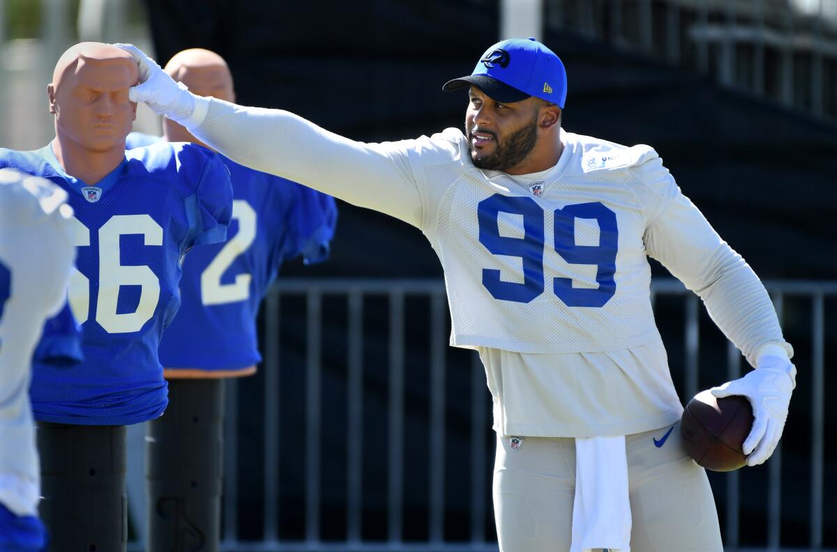 Rams defensive lineman Aaron Donald touches a mannequin during training camp.