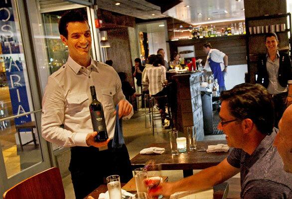 Manager and partner Christian Bertolini, who comes from the Trentino area of Italy, serves wine for his customers.
