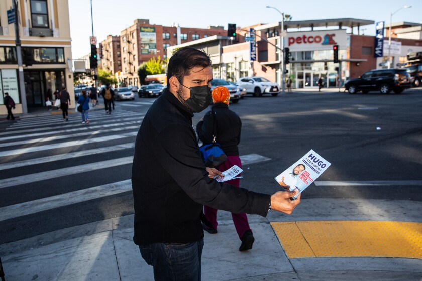A man hands out fliers on the street.