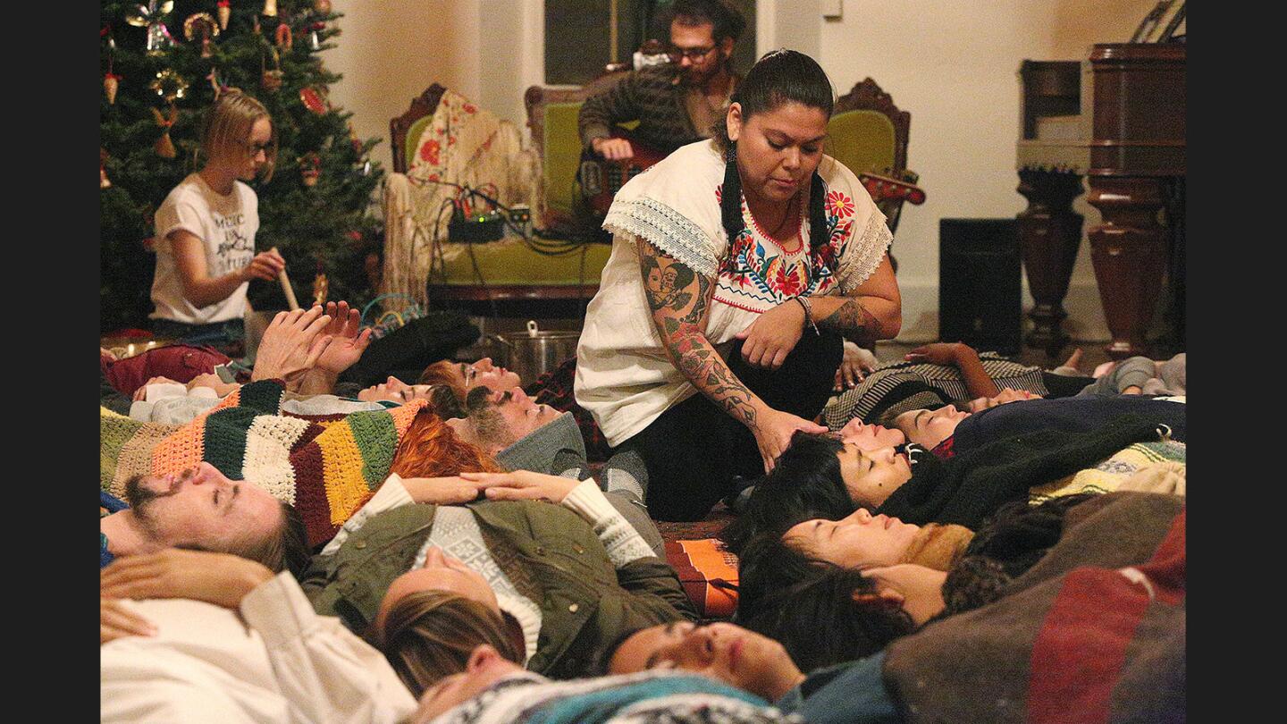 Tanya Love, who performs as Madre Jaguar, moves through the participants putting her hand on them to feel their energy during a cacao ceremony at Casa Adobe de San Rafael in Glendale on Friday, December 8, 2017. Tonya Love, aka Madre Jaguar, lead the gathering of about 25 with live music by Electric Sound Bath.