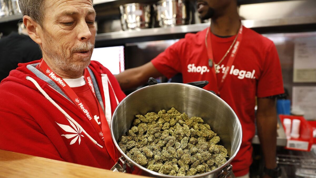 On the first day of recreational marijuana sales, Jeff Cosper shows the inside of a stainless steel pot filled with marijuana for sale at MedMen in West Hollywood.