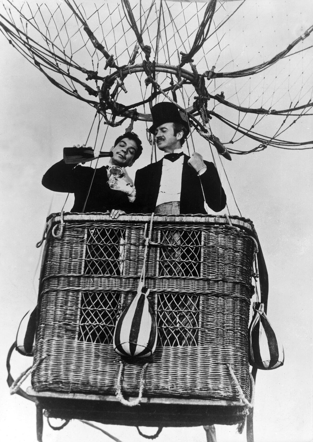 Two men in a balloon gondola drink Champagne in “Around the World in 80 Days.”