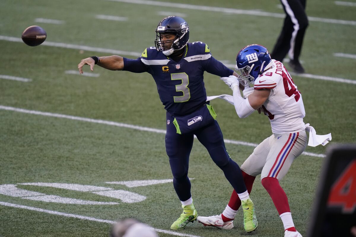 Seattle Seahawks quarterback Russell Wilson (3) passes under pressure from New York Giants linebacker Carter Coughlin (49) during the second half of an NFL football game, Sunday, Dec. 6, 2020, in Seattle. The Giants won 17-12. (AP Photo/Elaine Thompson)