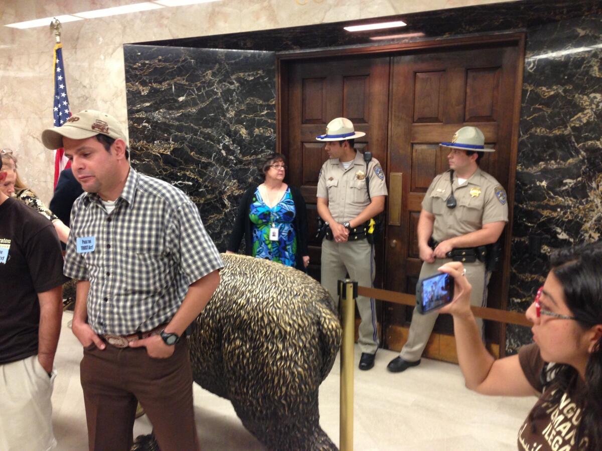 California Highway Patrol officers stand guard outside Gov. Jerry Brown's Capitol office, where activists are rallying and hoping to meet with Brown. A law that makes it harder to deport illegal immigrants was approved by the Senate.