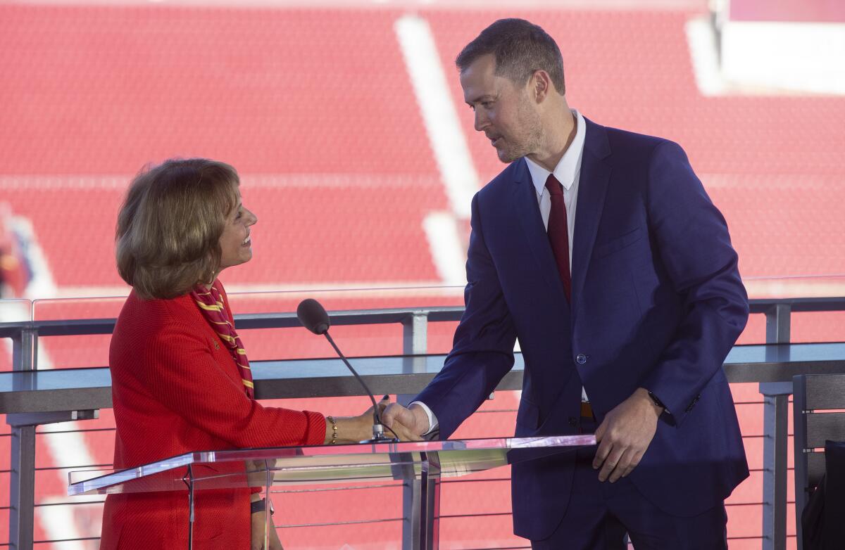 Carol Folt shakes hands with Lincoln Riley 