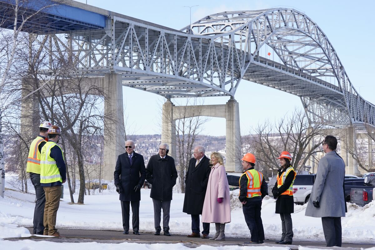 President Joe Biden and first lady Jill Biden visit the John A. Blatnik Memorial Bridge that connects Duluth, Minn., to Superior, Wis., Wednesday, March 2, 2022, in Superior, Wis. Standing between the Biden's are Wisconsin Gov. Tony Evers and Minnesota Gov. Tim Walz. (AP Photo/Patrick Semansky)