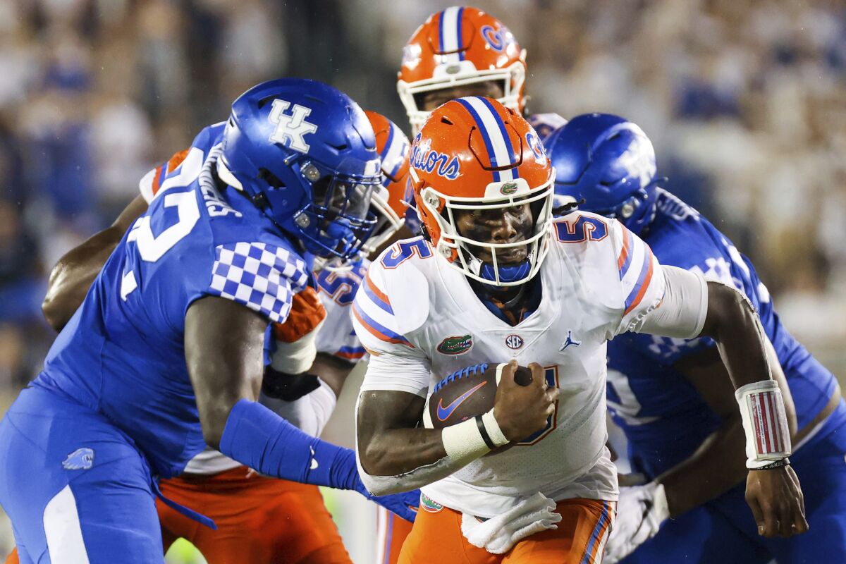 Florida quarterback Emory Jones (5) runs the ball upfield during the second half of an NCAA college football game against Kentucky in Lexington, Ky., Saturday, Oct. 2, 2021. (AP Photo/Michael Clubb)