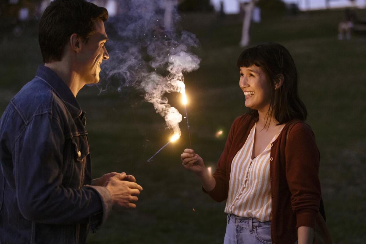 Finn Wittrock and Zoe Chao hold sparklers in the movie "Long Weekend."