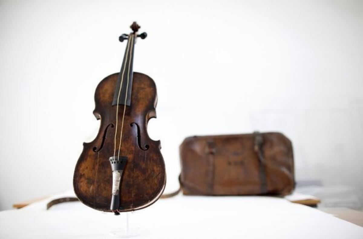 The violin played by bandmaster Wallace Hartley during the final moments before the sinking of the Titanic is shown, along with a leather carrying case initialed WHH.