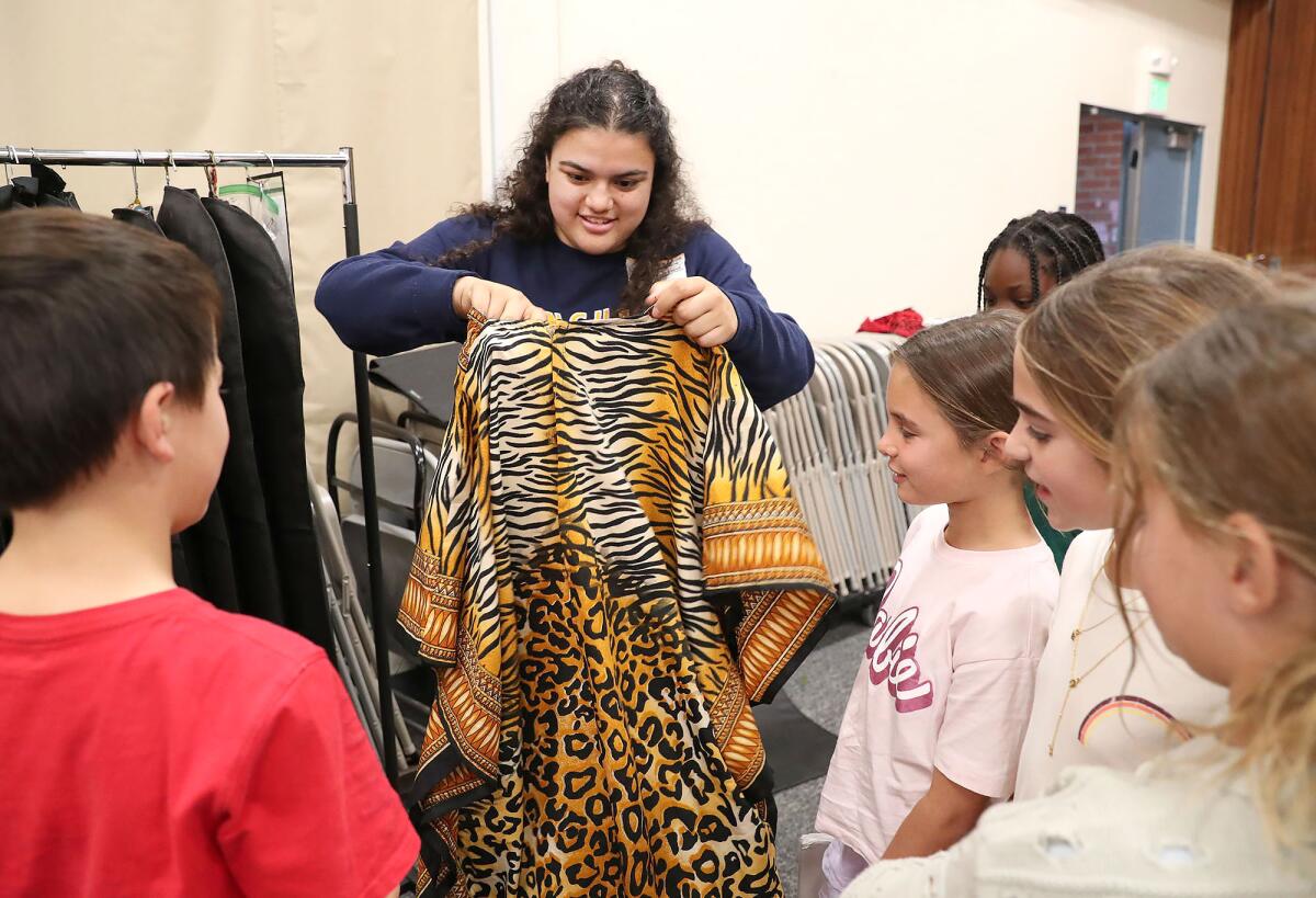 College Corps fellow Montana Leyva, a sophomore at Vanguard University, looks for costumes for cast members.