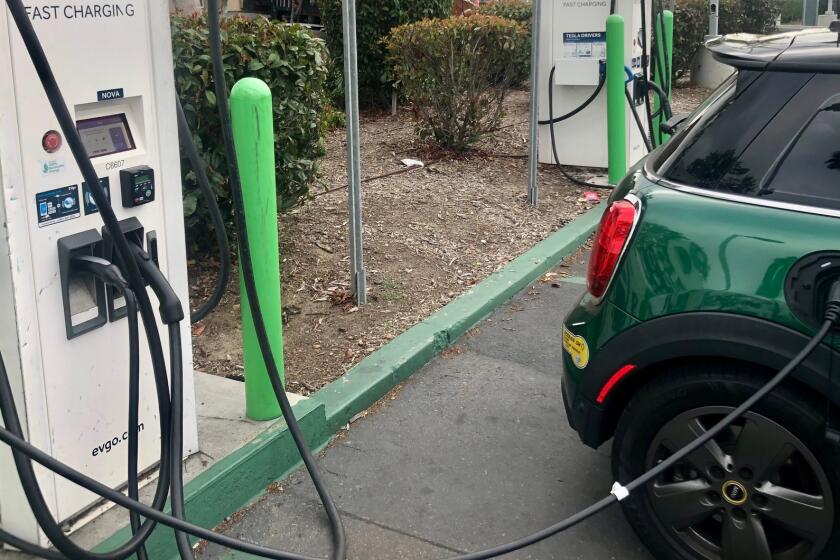 An electric vehicle charges its battery at a public station in Kearny Mesa.