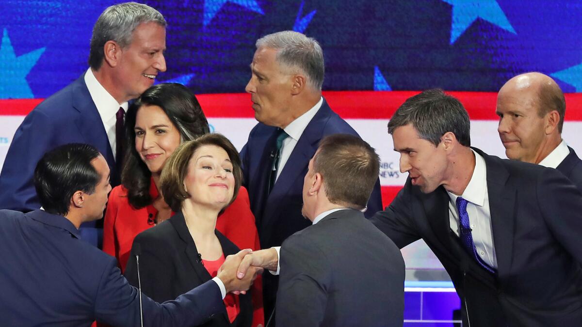 NBC's Chuck Todd greets Amy Klobuchar as Julián Castro, left, shakes hands with Beto O'Rourke. Behind them are, from left, Bill de Blasio, Tulsi Gabbard, Jay Inslee and John Delaney.