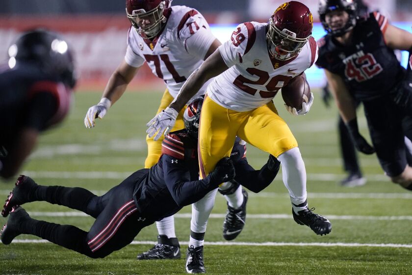 Southern California running back Vavae Malepeai (29) drags a Utah player along on a carry during the first half during an NCAA college football game Saturday, Nov. 21, 2020, in Salt Lake City. (AP Photo/Rick Bowmer)