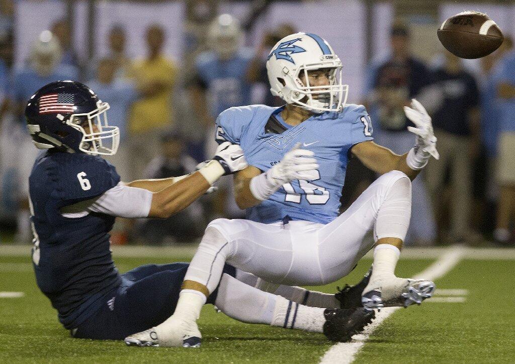 Newport Harbor High's Nate Harding (6) prevents Corona del Mar's Reece Perez from making a catch during the first half in the Battle of the Bay.