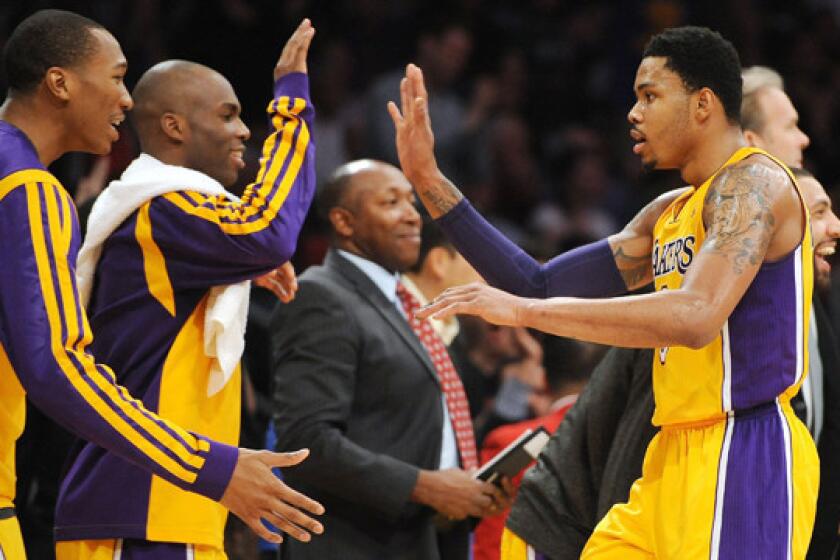 Lakers guard Kent Bazemore, right, celebrates with teammates Wesley Johnson, left, and Jodie Meeks during the Lakers' 101-92 win Friday over the Boston Celtics.