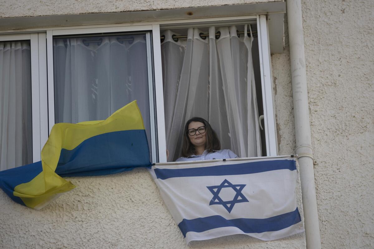 Woman at window with Israeli and Ukrainian flags