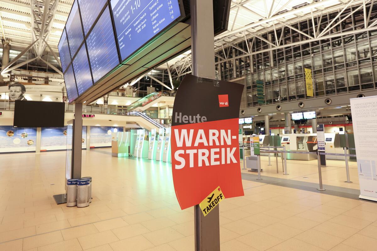A poster with the inscription "Warning strike!" hangs in Terminal 2 at the airport in Hamburg, Germany, Wednesday, Jan. 31, 2024. A union has called on security staff at most of Germany’s major airports to stage a one-day strike on Thursday as it steps up pressure on employers in a pay dispute. (Bodo Marks/dpa via AP)