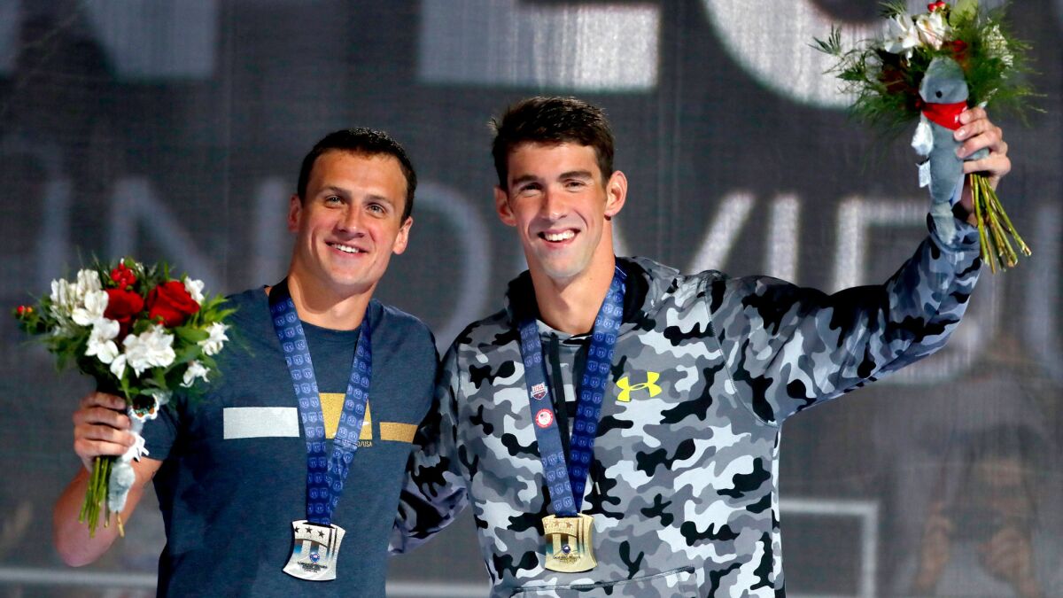 Ryan Lochte, left, and Michael Phelps celebrate on the podium together after the 200-meter individual medley at the U.S. Olympic swimming trials on Friday night.