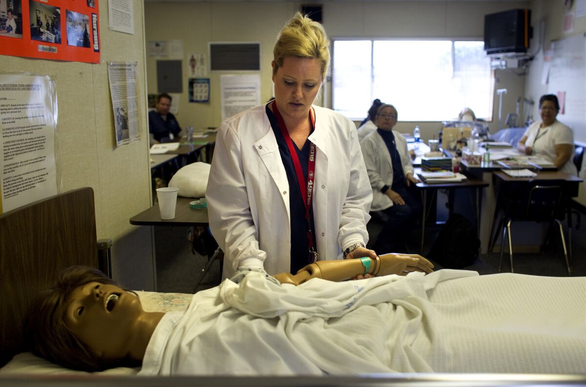 Nursing student Tiffany Bonham with a dummy patient