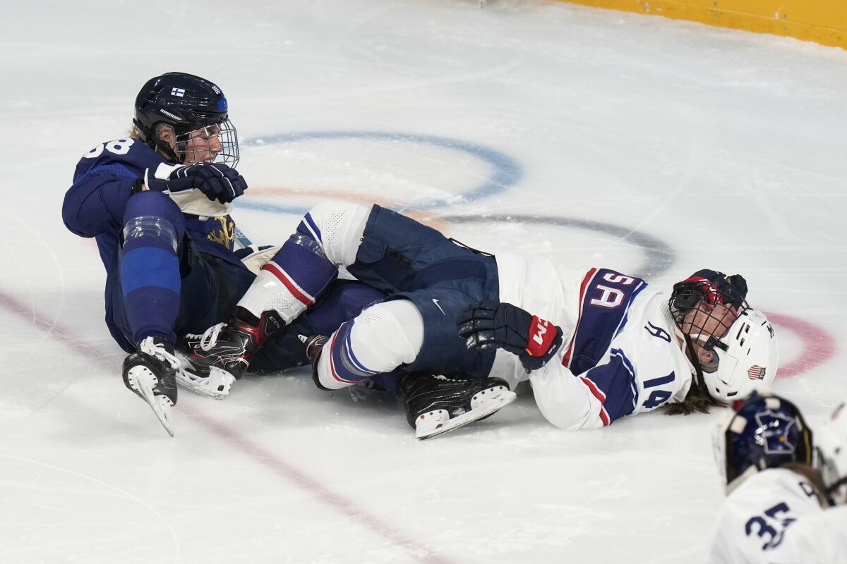 United States' Brianna Decker lies on the ice after colliding with Finland's Ronja Savolainen.