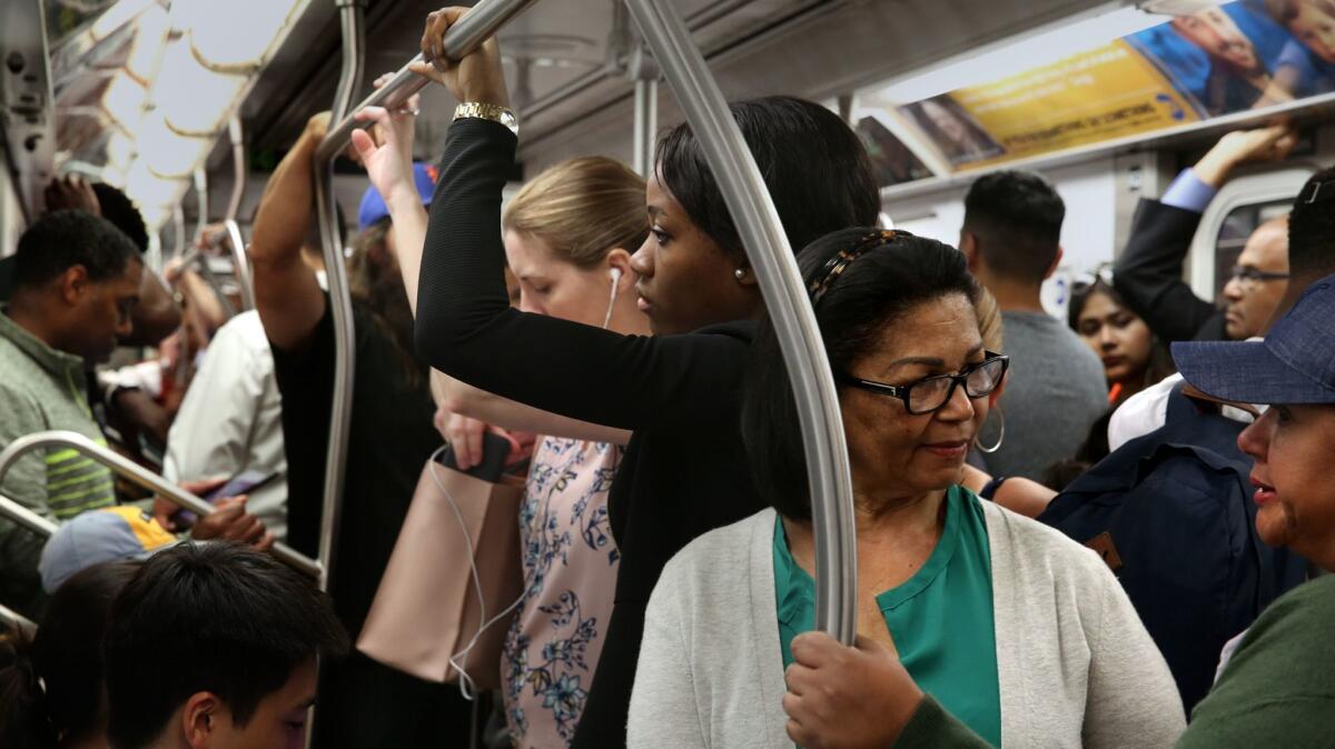 Passengers wait during a delay on the express No. 4 train as it goes uptown on June 28. Train delays can often lead to overcrowding.