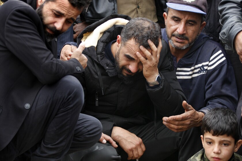 Syrian Maher al-Abdallah, center, mourns his wife and three children who died in their sleep after inhaling toxic fumes from burning coal to heat their room, during their funeral procession in Al-Wasta village near the southern port city of Sidon, Lebanon, Sunday, Jan. 2, 2022. Lebanon, a country of 6 million people, is home to 1.5 million Syrians who fled the now decade-old civil war in their country. (AP Photo/Mohammed Zaatari)