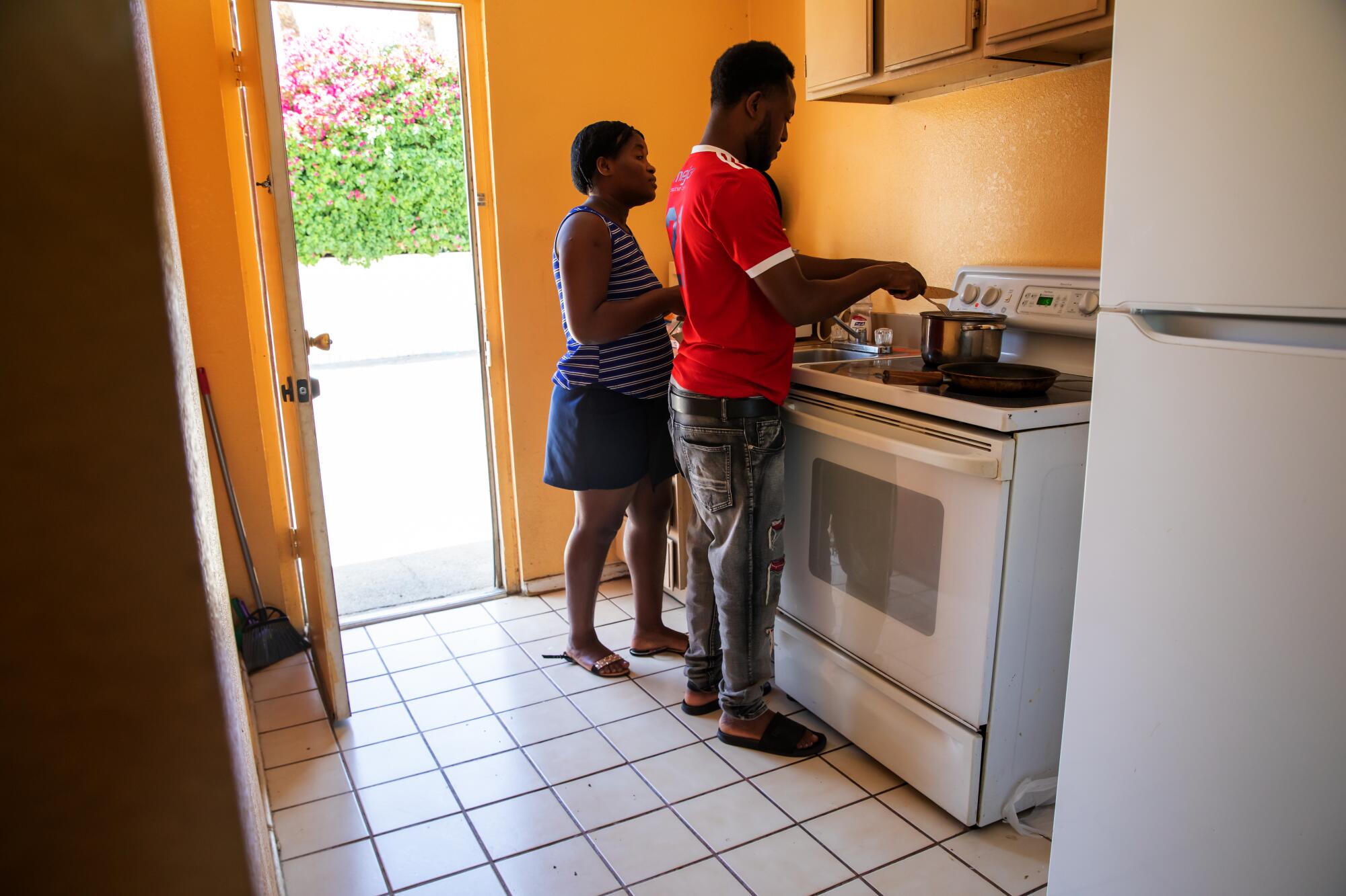 Haitian couple Sandia Siverne, left, and Beginne Morancy prepare for lunch in their room provided by Galilee Center.