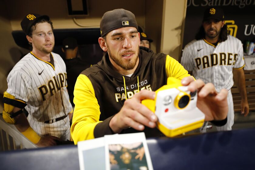 SAN DIEGO, CA - AUGUST 9: San Diego Padres' Joe Musgrove takes a photo with a Polaroid camera of Manny Machado during an interview after he hit a walk-off home run against the San Francisco Giants in the ninth inning at Petco Park on Tuesday, August 9, 2022 in San Diego, CA. (K.C. Alfred / The San Diego Union-Tribune)
