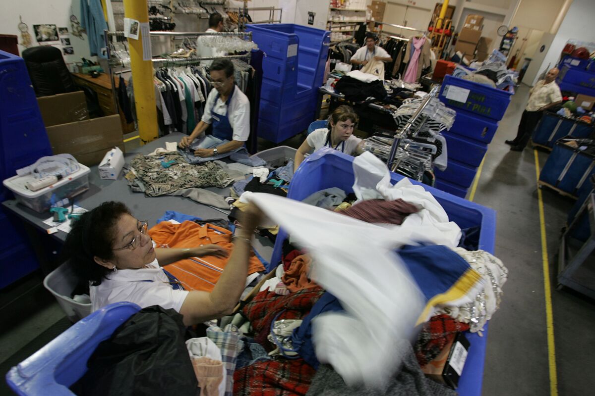 Goodwill employees sorted clothes in the production area of a Hollywood store in 2007. Drug tests are no longer required for retail jobs at the nonprofit.