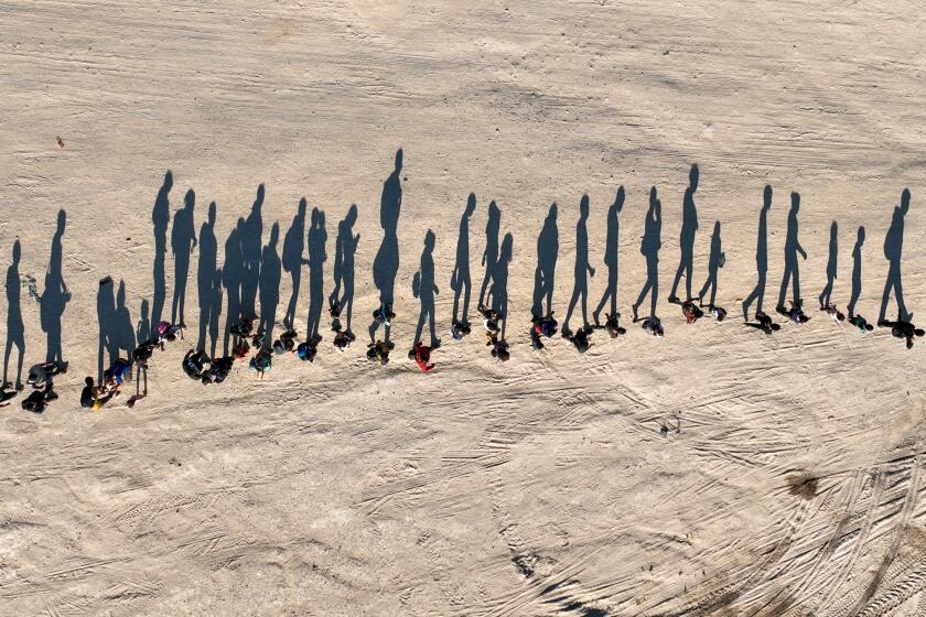 Eagle Pass, Texas, Saturday, September 23, 2023 - People who crossed the US/Mexico border are led, single file, to a border patrol processing center along the banks of the Rio Grande. (Robert Gauthier/Los Angeles Times)