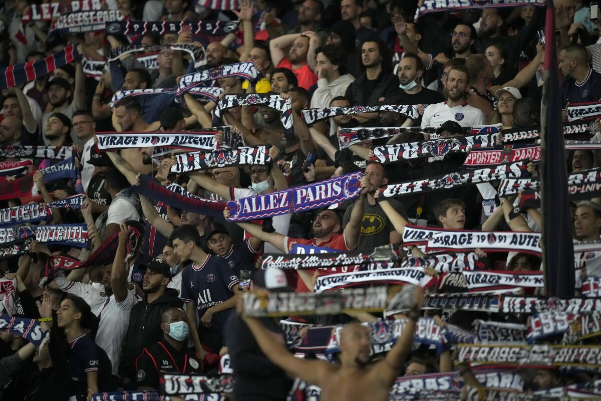 Hinchas del Paris Saint-Germain sostienen sus bufandas