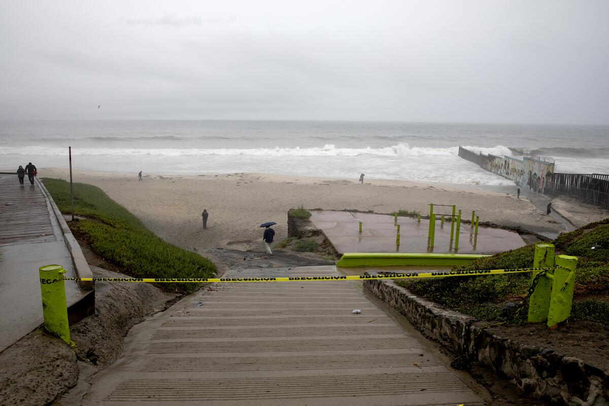People ignore caution signs for beach closings at Las Playas de Tijuana as Tropical Storm Hilary heads toward Tijuana.