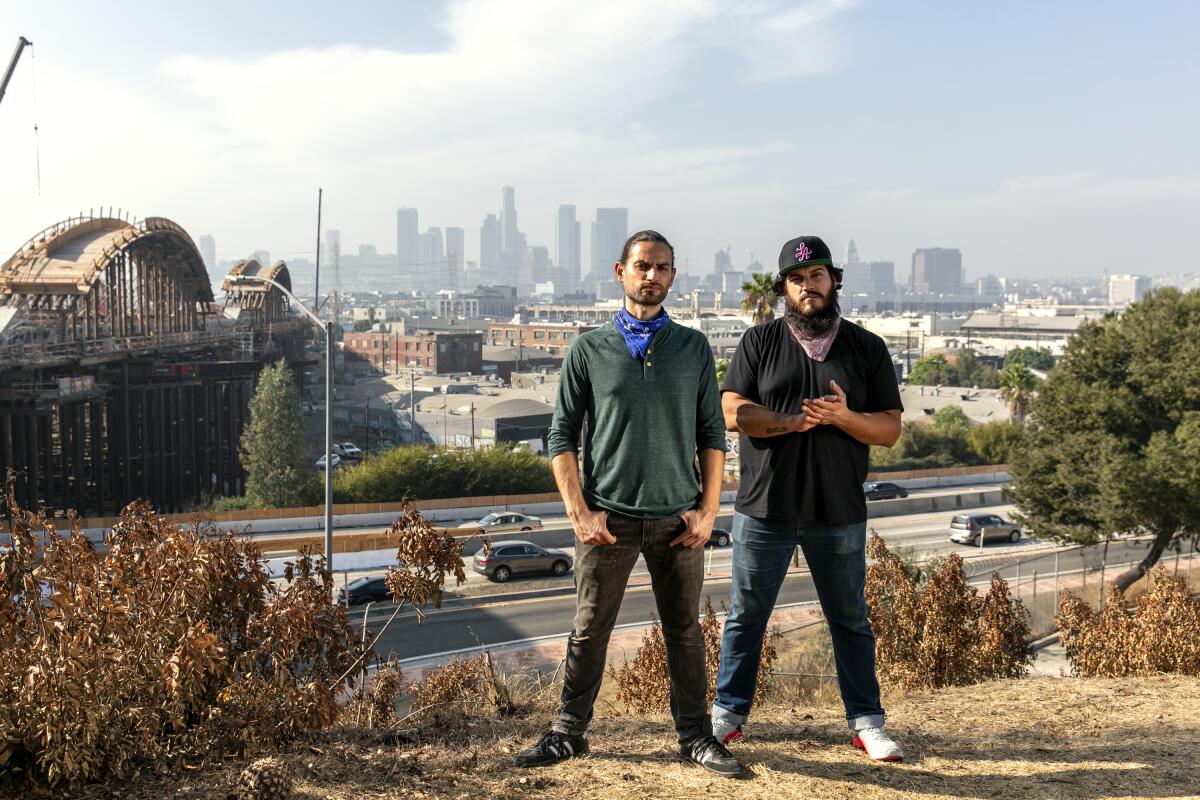 Damián Diaz, left, and Othón Nolasco, cofounders of nonprofit No Us Without You LA, with the L.A. skyline in the background