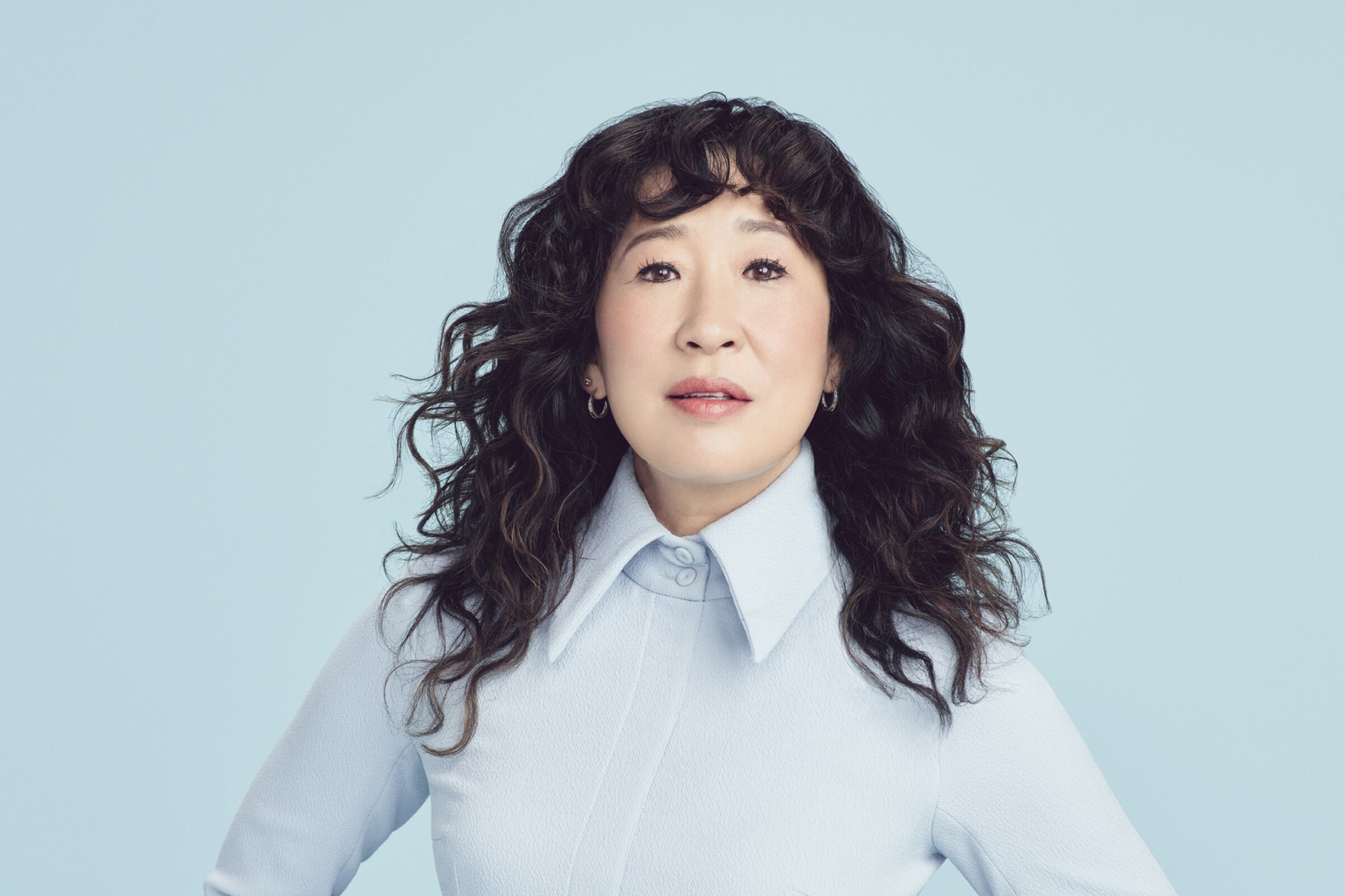 Portrait of Sandra Oh on a baby blue background