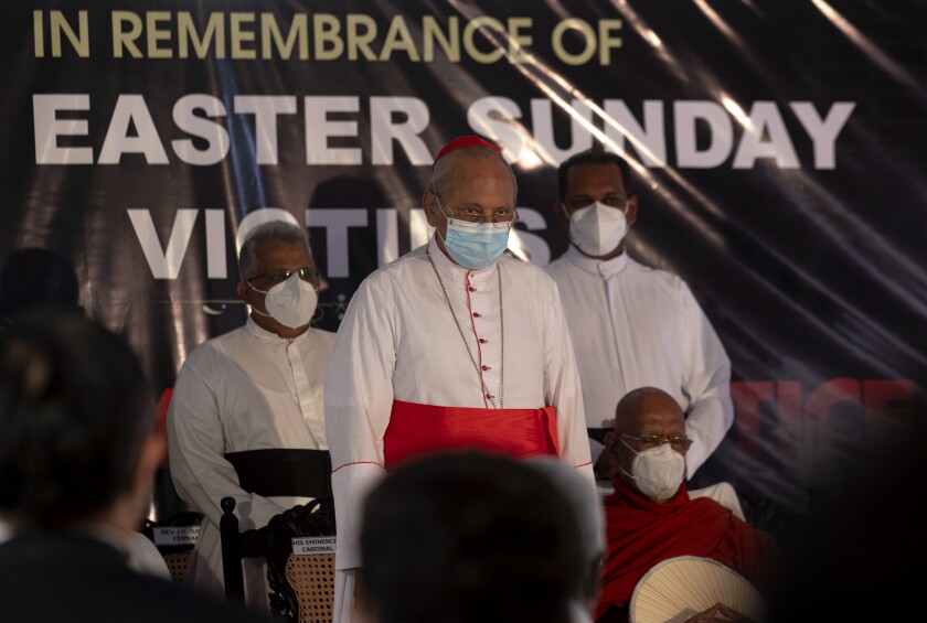 FILE- In this April 21, 2021 file photo, Cardinal Malcolm Ranjith, archbishop of Colombo, center, observes two minute silence for the victims of 2019 Easter Sunday attacks during a service at St. Anthony's Church in Colombo, Sri Lanka, Sri Lankan President Gotabaya Rajapaksa has ordered an investigation of allegations that some members of state intelligence agencies knew and met with people who carried out Easter Sunday bombings in 2019 that killed more than 260 people, a government official said. (AP Photo/Eranga Jayawardena, File)