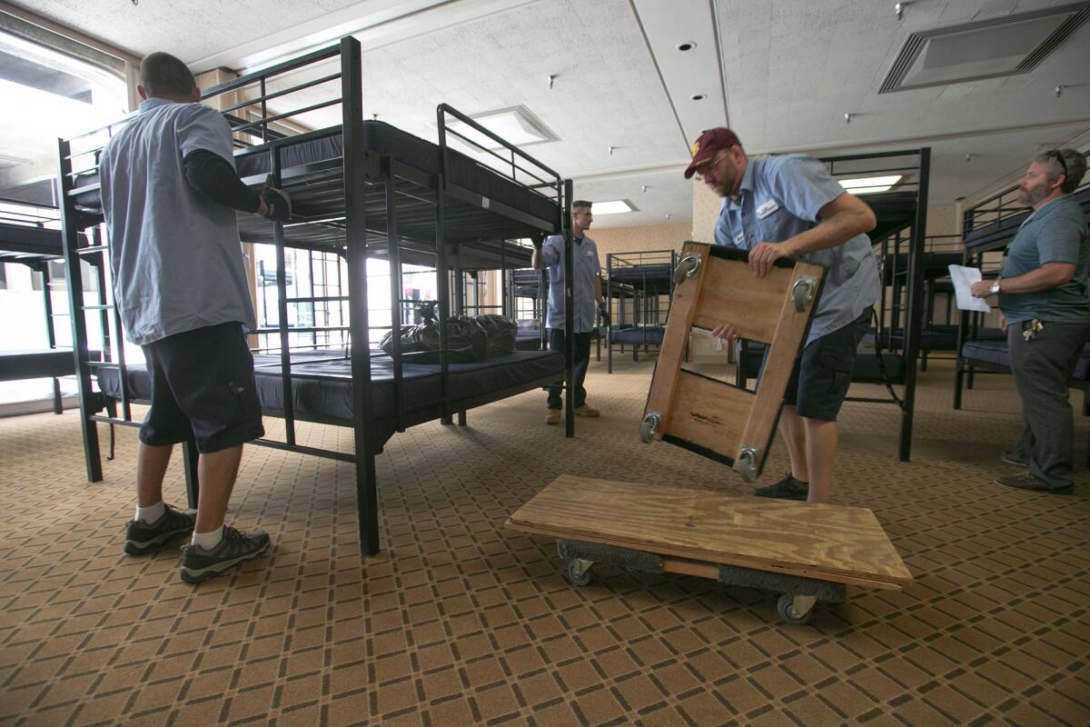 In this photo from April, workers are seen setting up beds in Golden Hall for what at the time was believed to be a temporary shelter. On Tuesday, the City Council voted to expand the shelter by 138 beds.