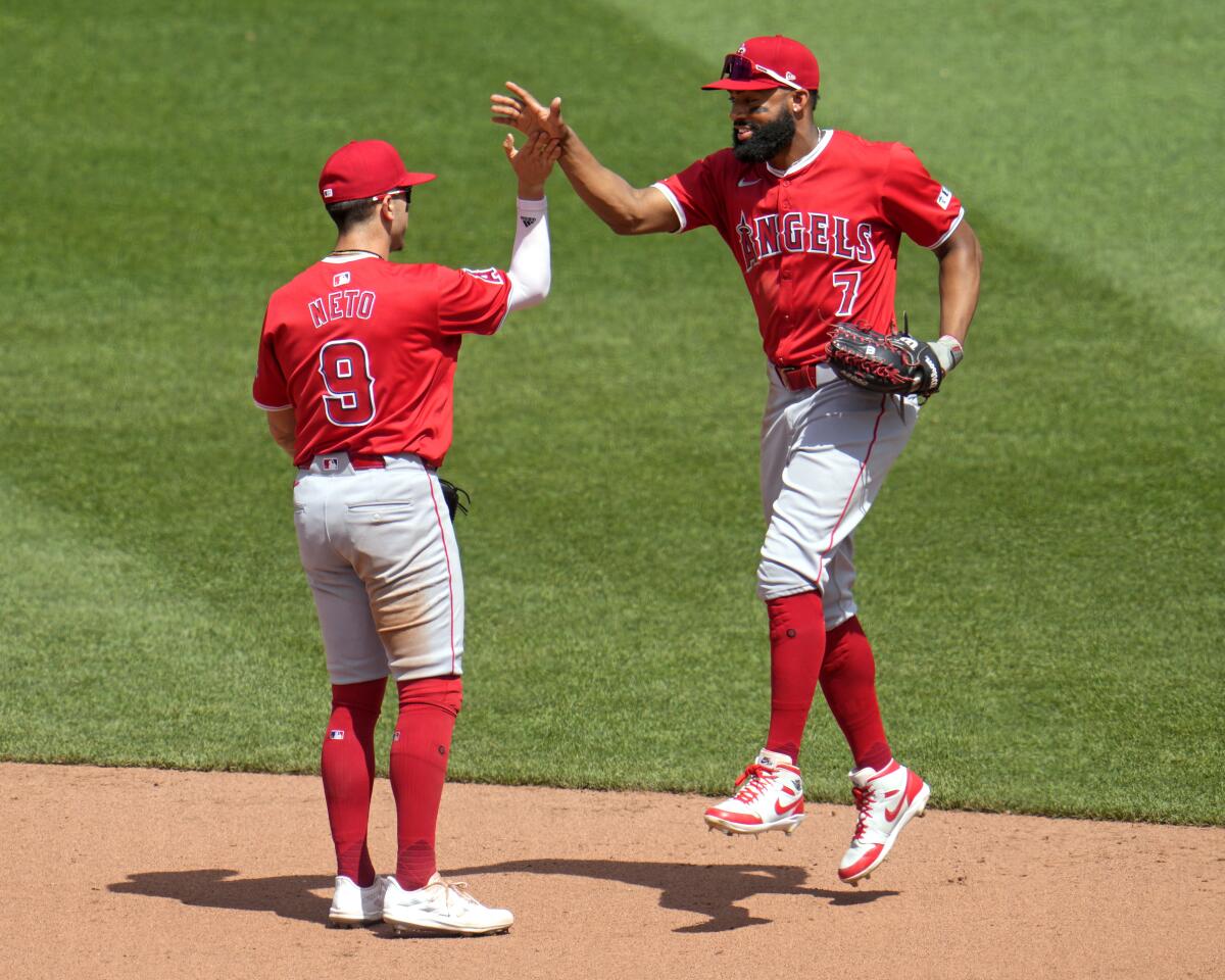 Zach Neto (9) y Jo Adell de los Angelinos de Los Ángeles celebran tras la victoria 5-4