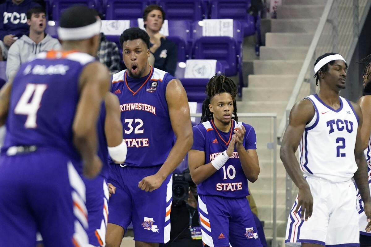 Northwestern State center Jordan Wilmore (32) reacts to scoring with Greedy Williams (10) and other teammates as TCU forward Emanuel Miller (2) looks away during the second half of an NCAA college basketball game in Fort Worth, Texas, Monday, Nov. 14, 2022. Northwestern State won 64-63. (AP Photo/LM Otero)